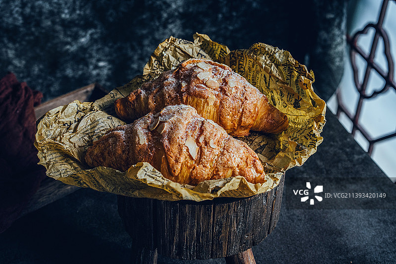 杏仁奶油可颂，牛角包，放在黄色油纸中图片素材