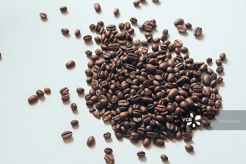 颗粒分明的烘焙咖啡豆特写，研磨成粉末后可用来制作浓香醇厚的咖啡，白底背景素材图片素材