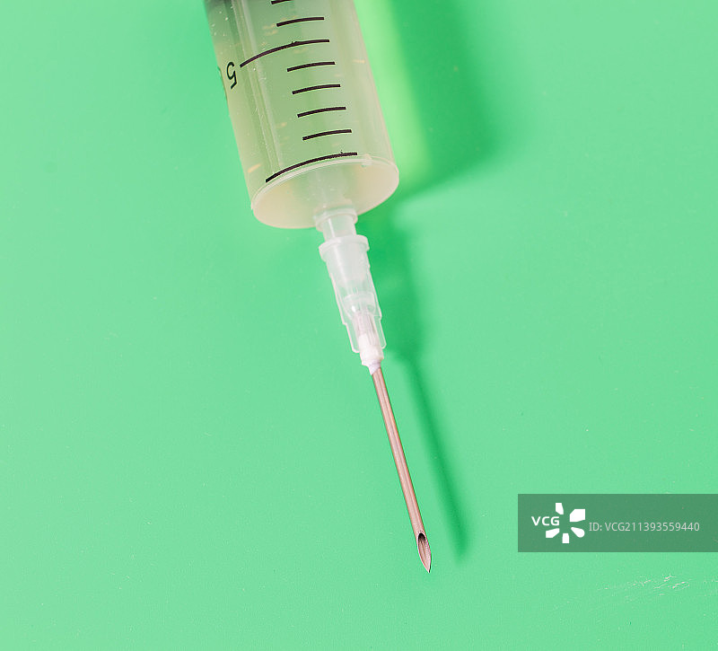 绿色背景下的注射器特写镜头图片素材