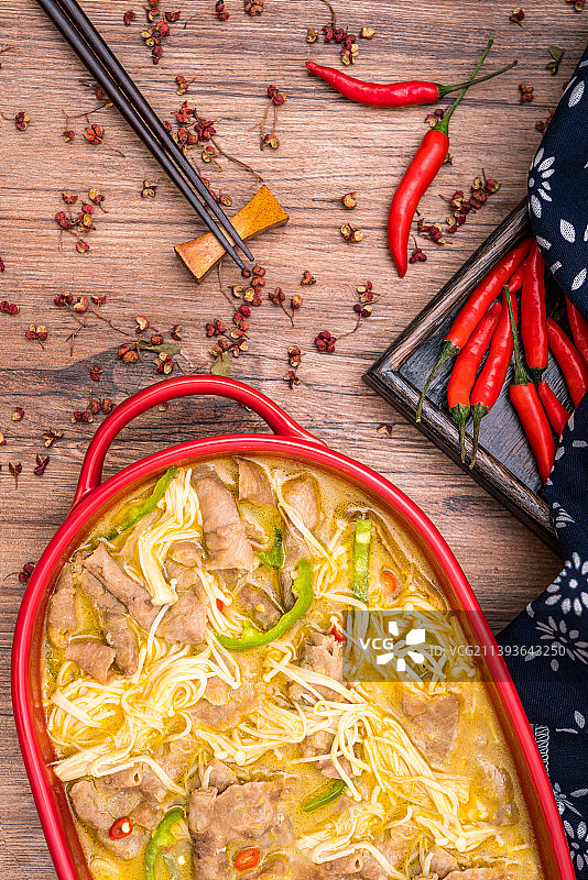 放在木桌上的一盘金针菇酸汤肥牛图片素材