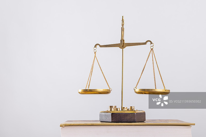 白色背景下放着的金色天平图片素材