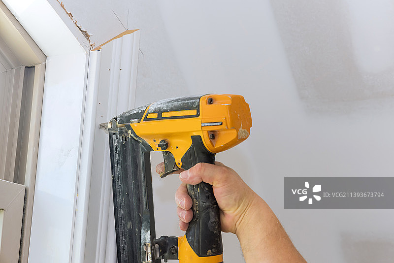 新房装修，木工使用射钉枪安装边框图片素材