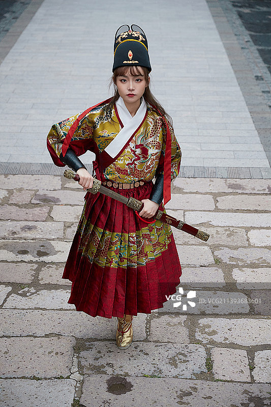 身穿锦衣卫飞鱼服手持宝剑的东方美少女图片素材