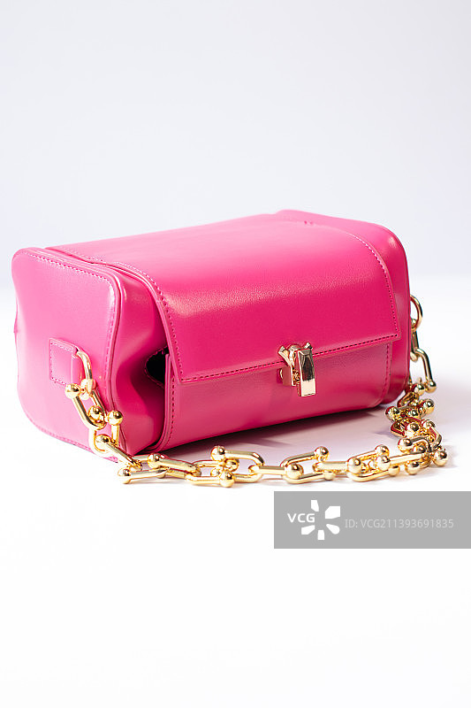 白色背景上孤立的金色链条粉色小手提包图片素材