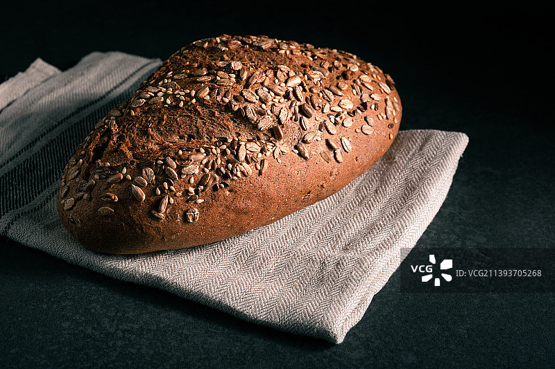 黑色背景下砧板上的面包的俯视照片图片素材