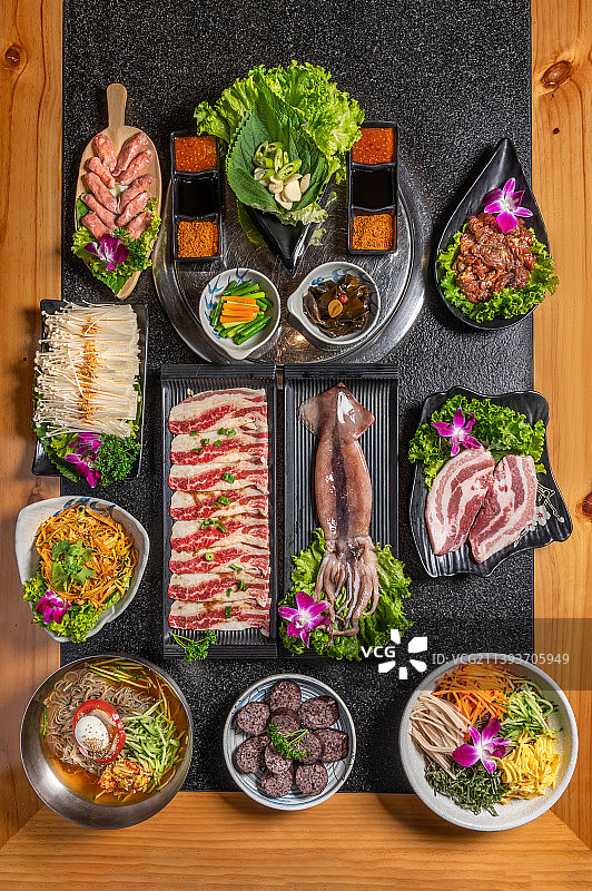 桌子上的韩式烤肉和配菜图片素材