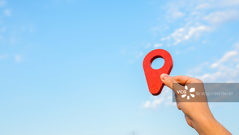 天空背景上手持的红色定位图钉，乌克兰图片素材