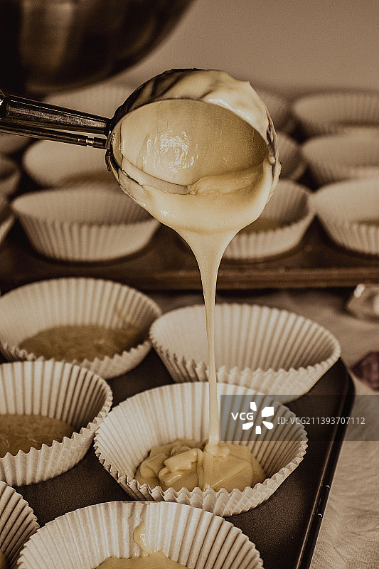 烘烤纸杯蛋糕，将面糊放入松饼模具中的肖像图片素材