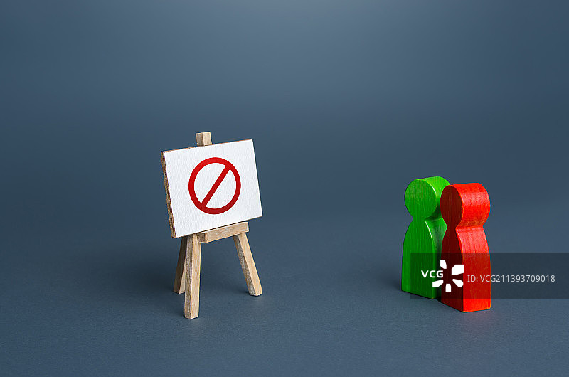 两个人正在看着一个带有禁止标志“NO”的画架图片素材
