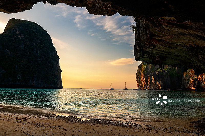 泰国甲米府皮皮岛玛雅海滩日落时分的石拱洞图片素材