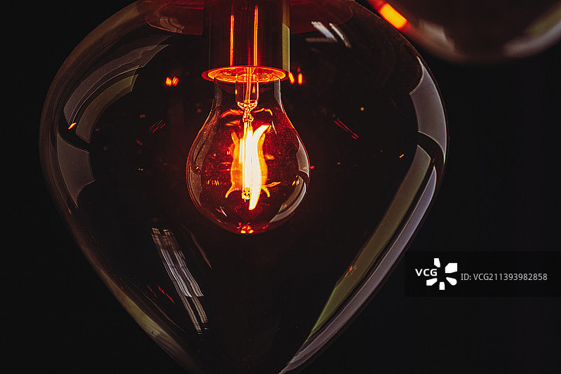 黑暗中透明玻璃球里发光的灯泡图片素材