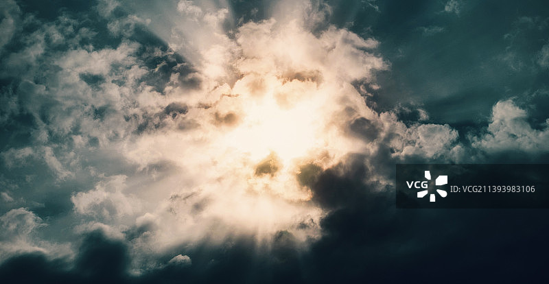 黑暗暴风雨天空中的阳光光线图片素材