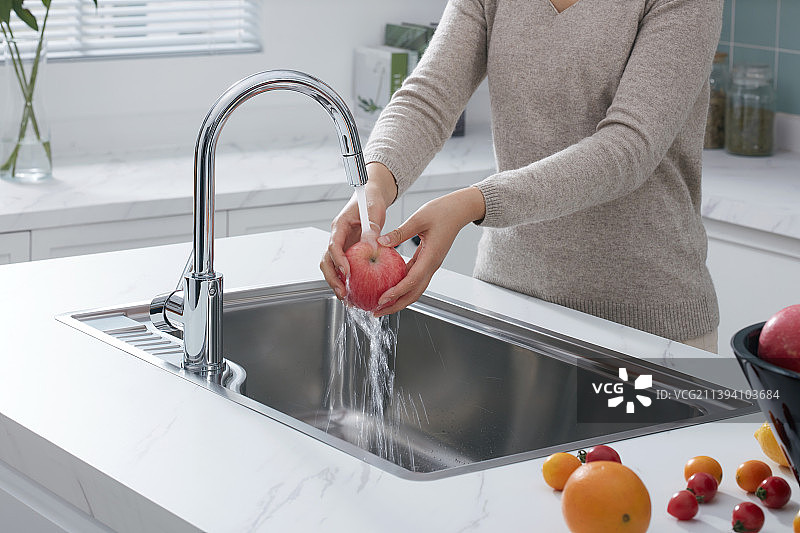 厨房中岛水槽前清洗水果图片素材