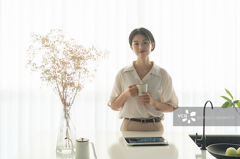 茶水吧前喝咖啡边工作的年青女白领图片素材