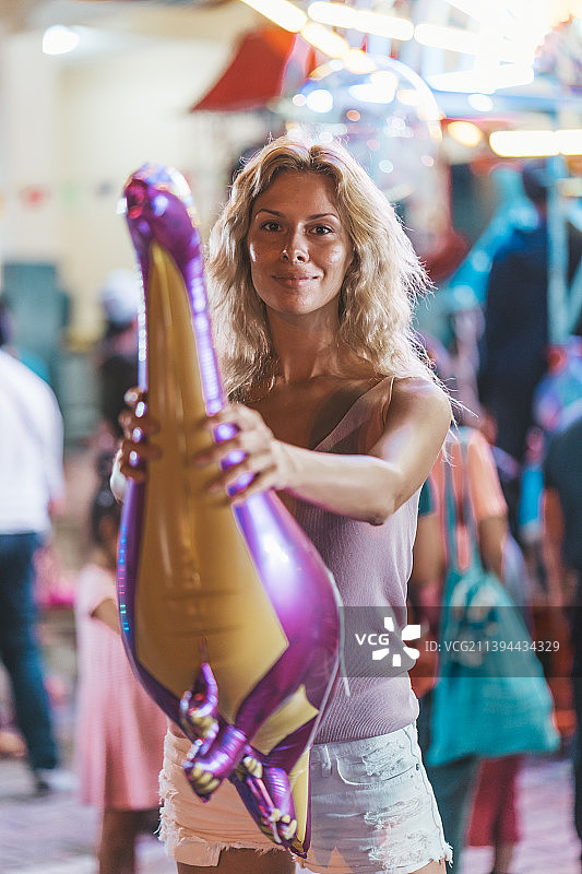 在泰国清迈市场里拿着气球动物的年轻女人图片素材
