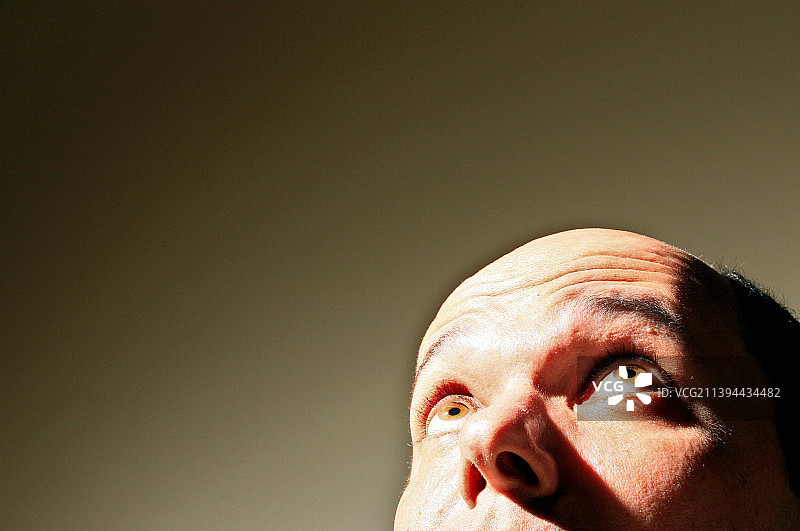 特写：沉思的成熟男人抬头望向灰色背景，巴西图片素材