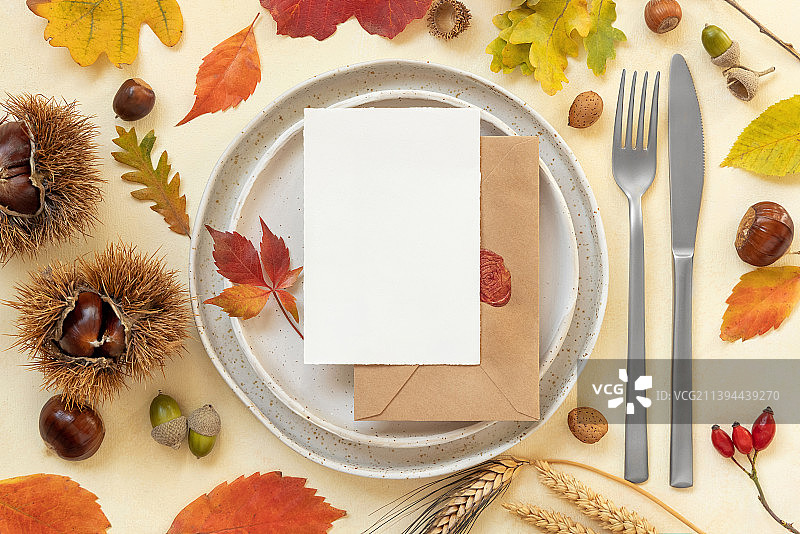 秋季餐桌：彩色树叶与竖版空白卡片样机图片素材