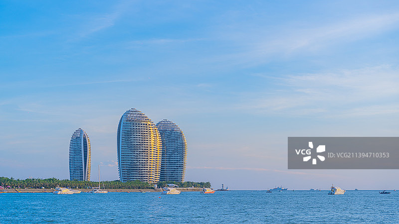三亚湾海面上夕阳下远处的亚特兰蒂斯酒店图片素材