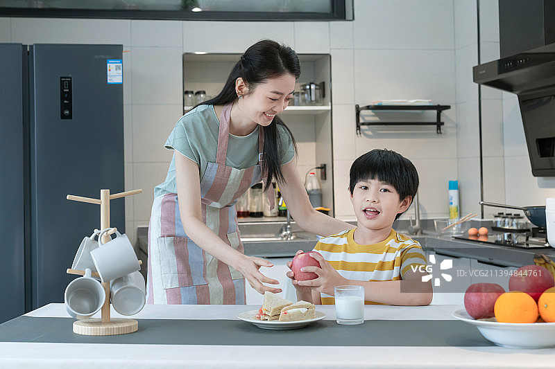 年轻妈妈给孩子做早餐图片素材