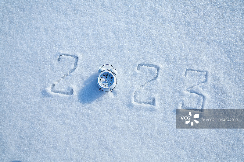 雪地上的手写2023年，闹钟图片素材