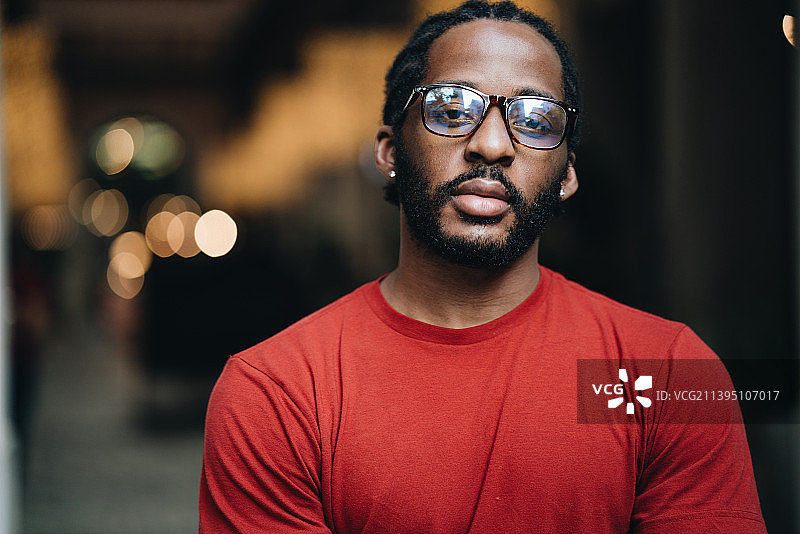 穿着红色T恤和戴眼镜的年轻黑人男子肖像，泰国清迈图片素材
