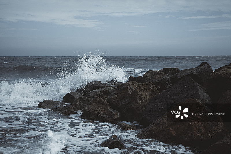 英国福克斯通海滩岩石上的水花图片素材