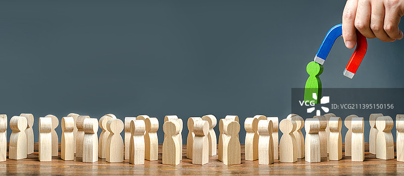 用磁铁将绿色小人从人群中拉出来图片素材