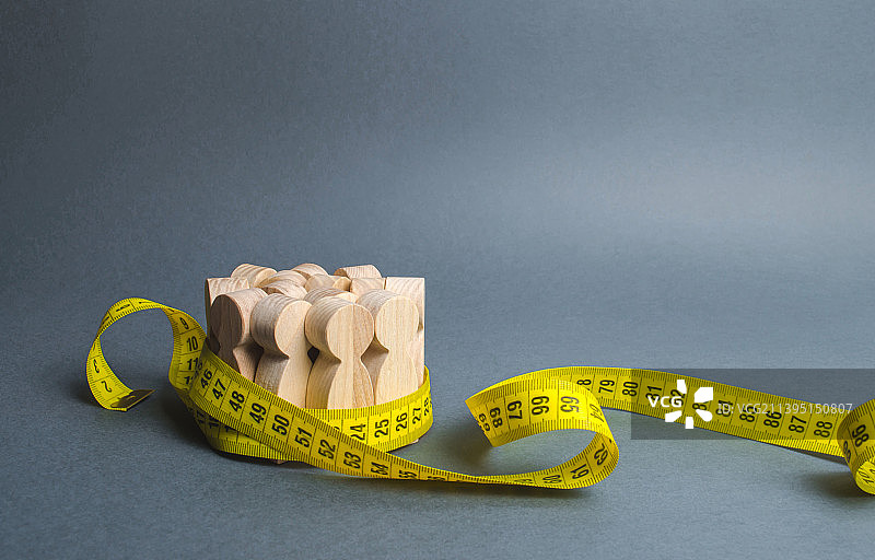 被卷尺束缚的木制人偶图片素材