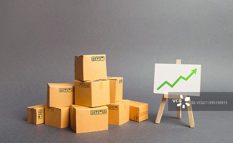 大量纸箱和带有绿色向上箭头示意图的白板图片素材