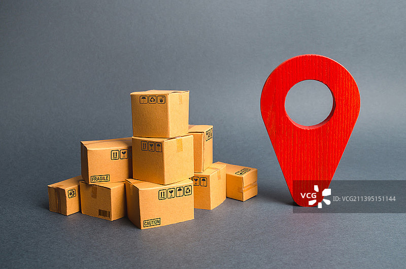 一堆纸板箱和一个红色定位图钉图片素材