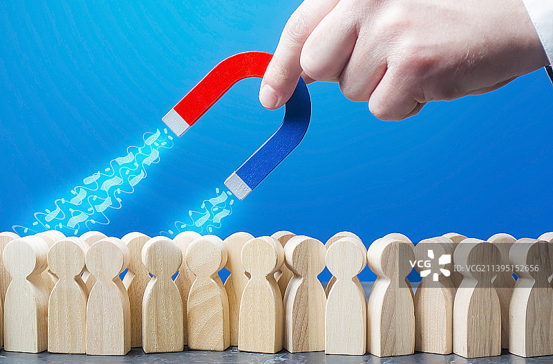 男子用磁铁吸引人群中的钱图片素材