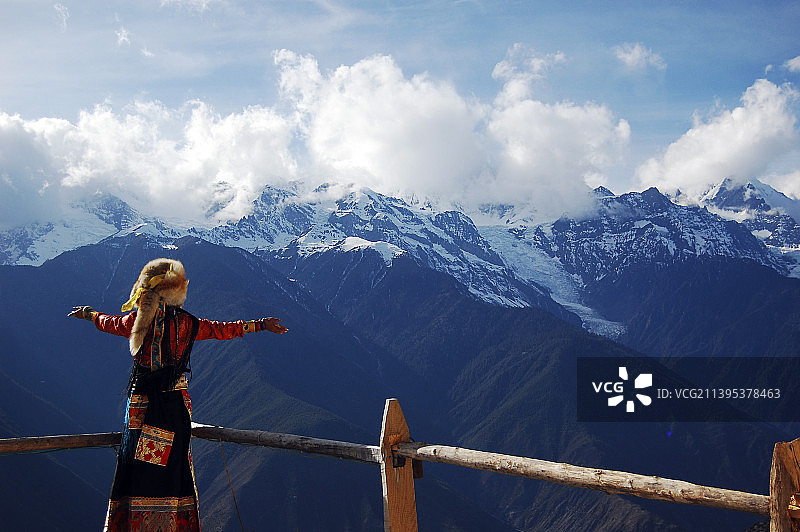 中国云南风景图 以为藏族歌手面对远处的梅里雪山歌唱 梅里十三峰 冰川冰封图片素材