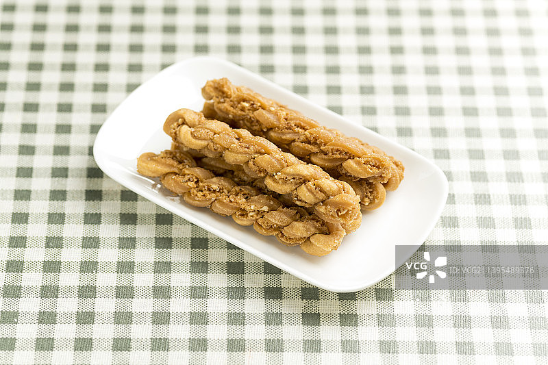 一盘特色小吃麻花特写格子桌布背景图片素材