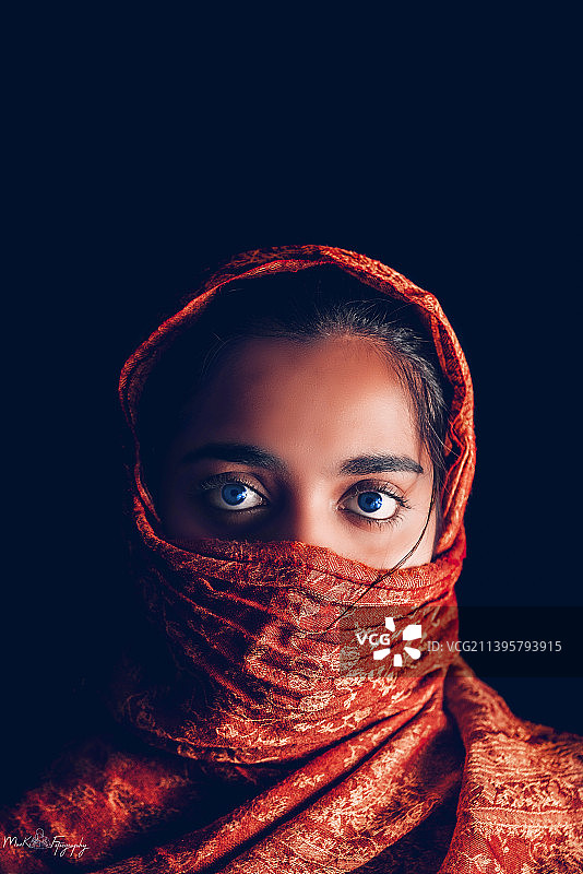 黑色背景下的围巾年轻女子肖像图片素材