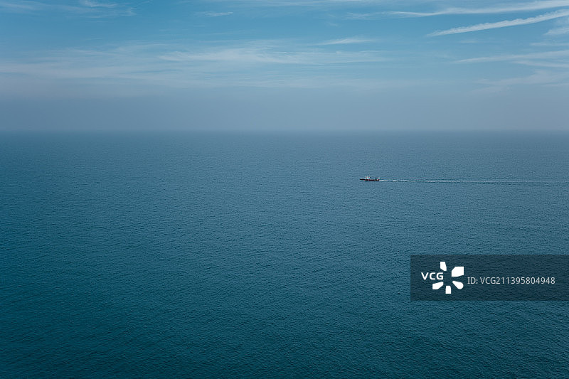 宁静海面上的小渔船，清晨留白图片素材