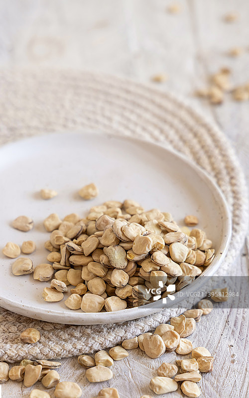 木桌上的一盘生干草豌豆，意大利称为Cicerchia的豆类图片素材