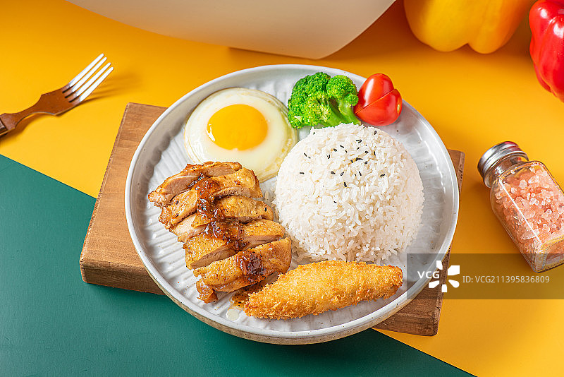 餐桌上黑椒鸡排炸鳕鱼拼饭的高视角视图图片素材