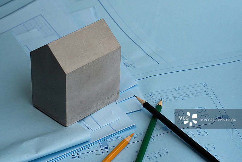 放在蓝图上的铅笔和房子形状的混凝土块图片素材