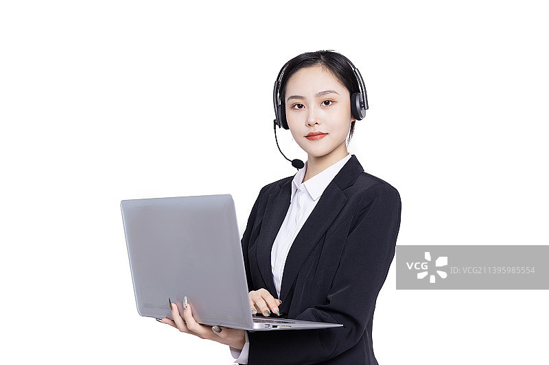 年轻女性客服带着耳麦使用电脑工作图片素材