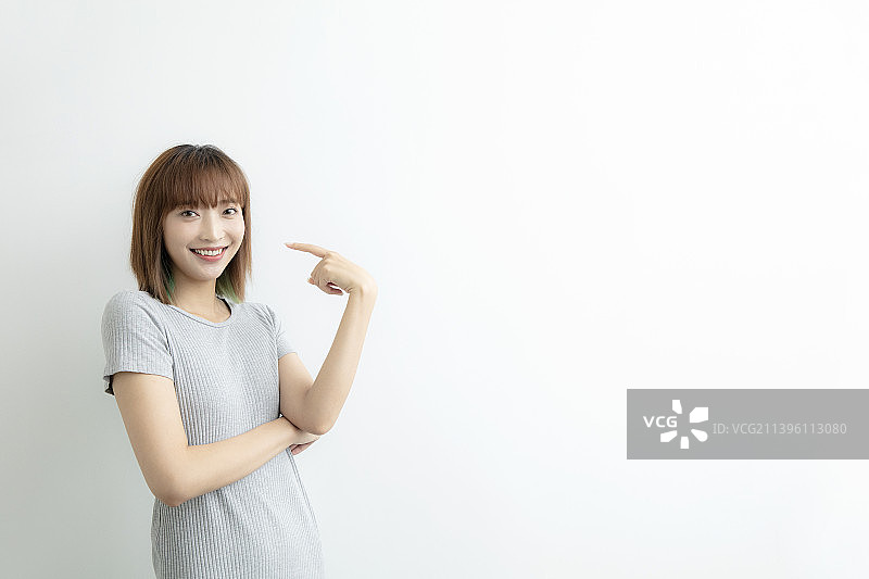 微笑着做手势的年轻女士图片素材