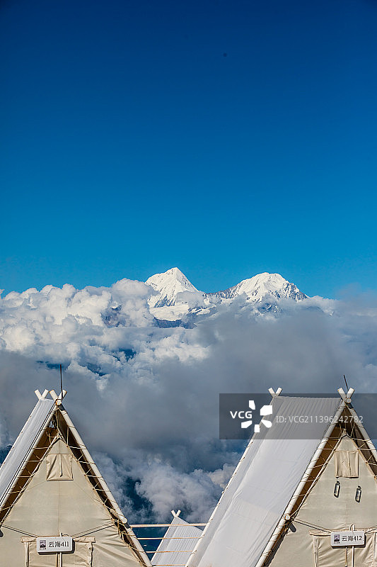 牛背山上的帐篷与雪山云海图片素材