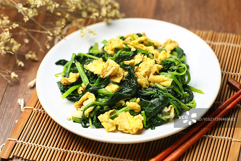 菠菜炒鸡蛋放在白色盘子里图片素材