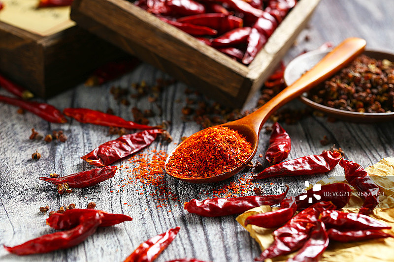一勺辣椒粉和干辣椒放在木纹背景上图片素材