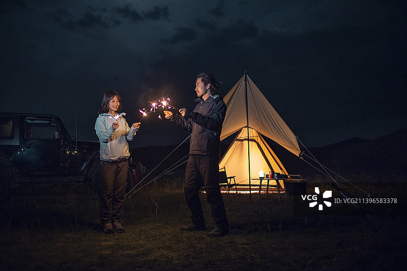 快乐的情侣户外露营放烟花图片素材