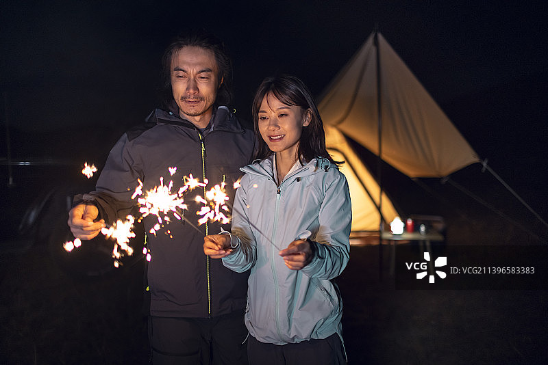 快乐的情侣户外露营放烟花图片素材