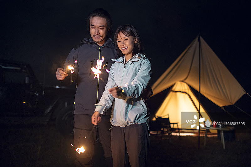 快乐的情侣户外露营放烟花图片素材