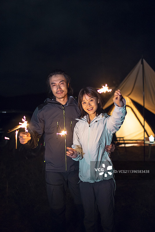 快乐的情侣户外露营放烟花图片素材