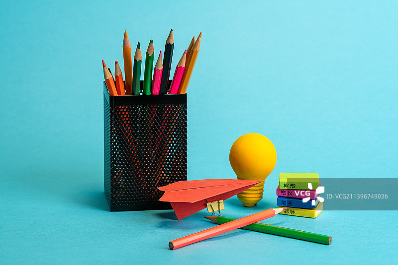 彩色铅笔黄色灯泡纸飞机和课本模型静物图图片素材
