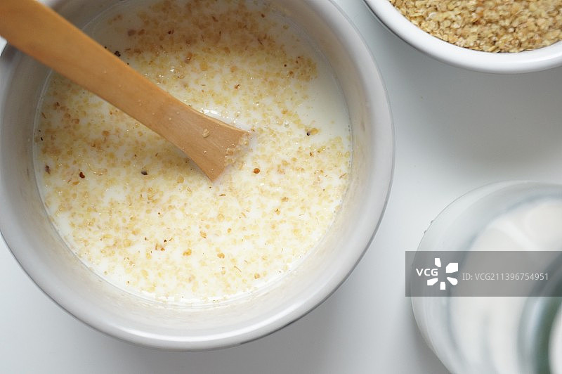 小麦胚芽，牛奶，牛奶瓶，玻璃瓶，陶瓷碗，营养早餐，牛奶泡小麦胚芽，代餐，早餐，倒牛奶，泡小麦胚芽，文图片素材