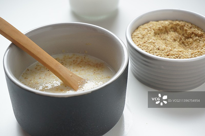 小麦胚芽，牛奶，牛奶瓶，玻璃瓶，陶瓷碗，营养早餐，牛奶泡小麦胚芽，代餐，早餐，倒牛奶，泡小麦胚芽，文图片素材